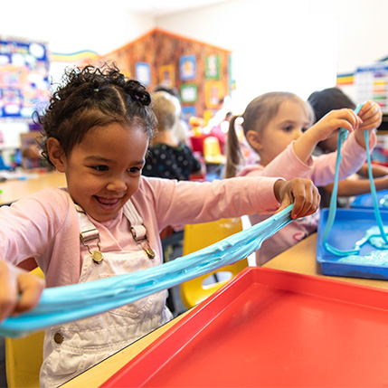 kids playing with slime at preschool table