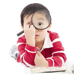 kid looking through magnifying glass