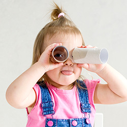 Girl looking through cardboard binoculars