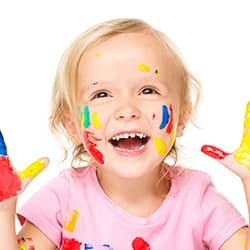 girl smiling with paint on face and hands