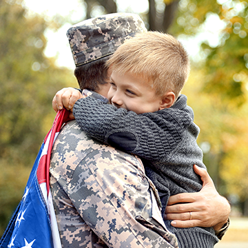 niño abrazando a su padre con uniforme
